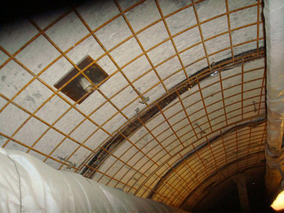 Heavy wire mesh fabric was attached to the tunnel walls and ceiling leaving a 2" gap between the wire and the surface